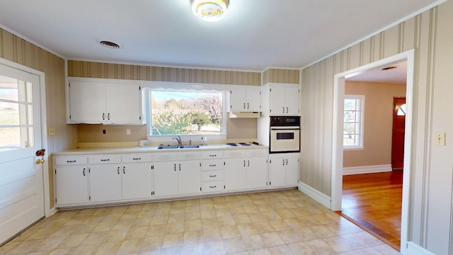 kitchen featuring white cabinets, crown molding, white appliances, and sink