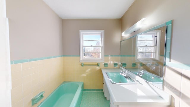 bathroom featuring tile patterned flooring, plenty of natural light, tile walls, and vanity