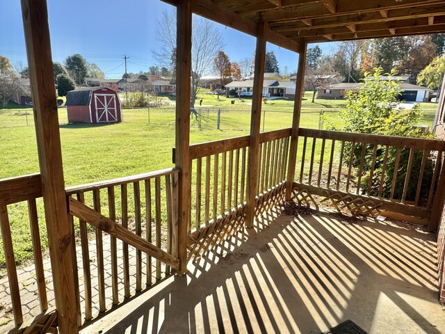 wooden deck featuring a yard and a shed