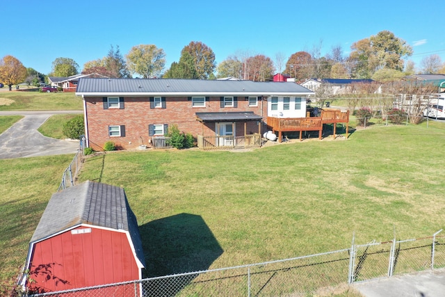 rear view of house with a storage shed, a deck, and a yard