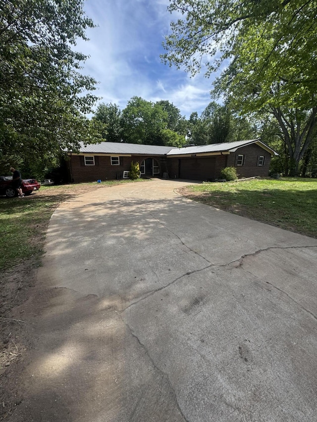 ranch-style house with driveway and a front lawn