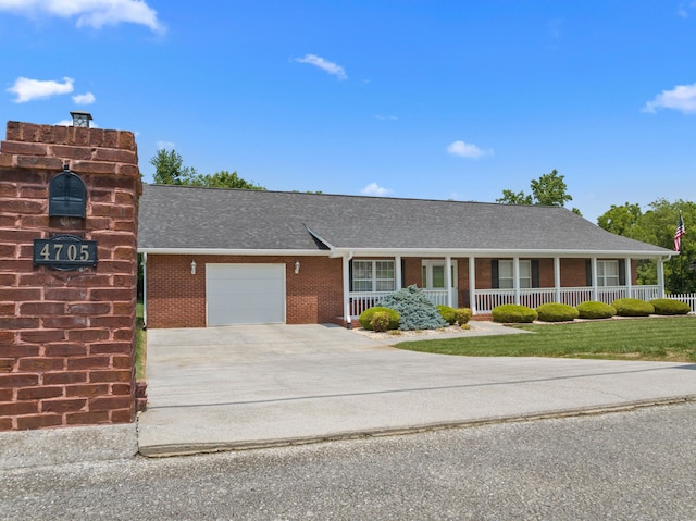 4705 E Hampton Blvd, Morristown, TN 37813 - view of front of house with covered porch, an attached garage, brick siding, concrete driveway, and a shingled roof