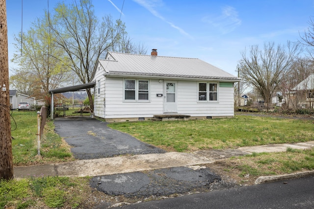 view of front facade featuring a carport, a front lawn, aphalt driveway, and metal roof