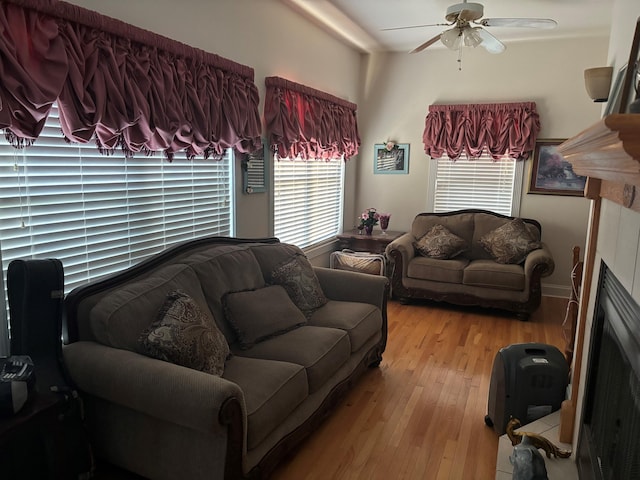 living room with ceiling fan, hardwood / wood-style flooring, healthy amount of natural light, and a fireplace