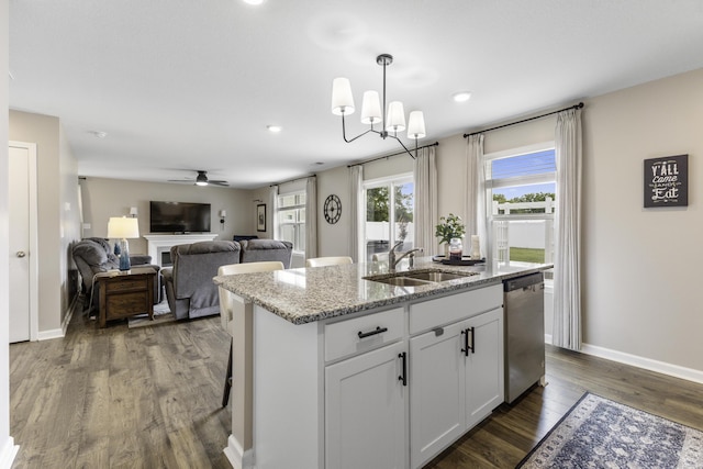 5021 Cottonseed Way, Morristown, TN 37813 - kitchen featuring dishwasher, a kitchen island with sink, dark wood-type flooring, light stone counters, and hanging light fixtures