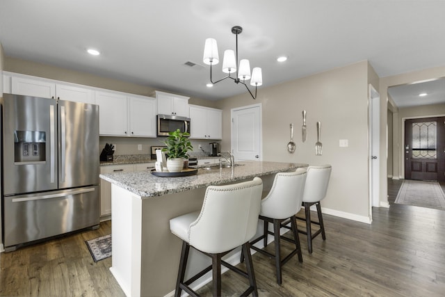 5021 Cottonseed Way, Morristown, TN 37813 - kitchen featuring stainless steel appliances, dark wood-style floors, a kitchen island with sink, white cabinetry, and light stone countertops