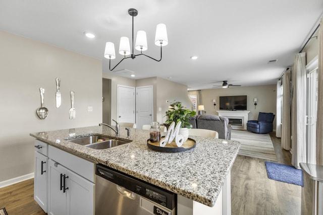 5021 Cottonseed Way, Morristown, TN 37813 - kitchen with stainless steel dishwasher, an island with sink, a ceiling fan, light wood-style flooring, and white cabinetry