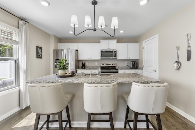 5021 Cottonseed Way, Morristown, TN 37813 - kitchen with stainless steel appliances, an island with sink, a breakfast bar area, white cabinetry, and recessed lighting