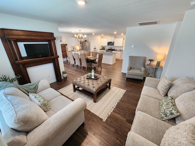 living room featuring an inviting chandelier, recessed lighting, dark wood-style flooring, and visible vents