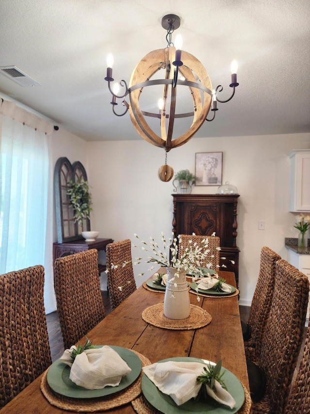 dining space featuring dark wood-style floors, a chandelier, and visible vents
