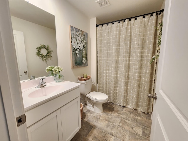 full bath with vanity, toilet, stone finish floor, curtained shower, and visible vents