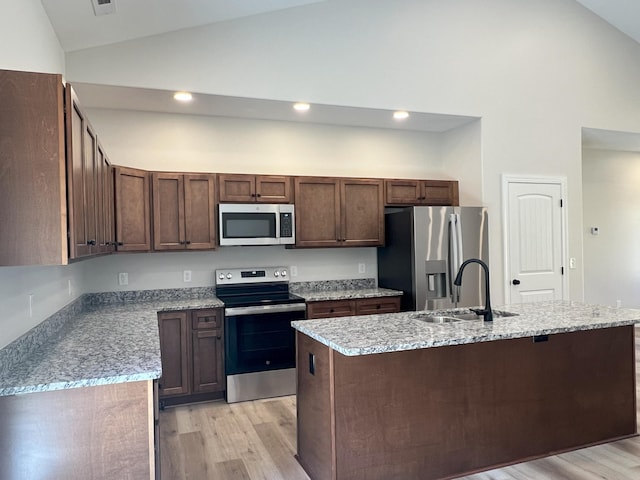 553 Sequoyah Dr, Morristown, TN 37813 - kitchen with stainless steel appliances, a sink, high vaulted ceiling, light wood-style flooring, and a center island with sink