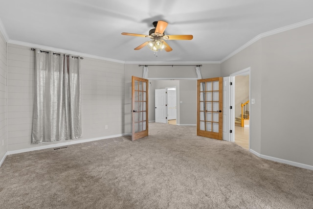 carpeted spare room featuring ornamental molding, ceiling fan, and french doors