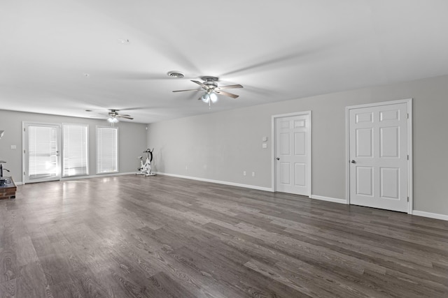 unfurnished living room featuring dark wood-type flooring and ceiling fan