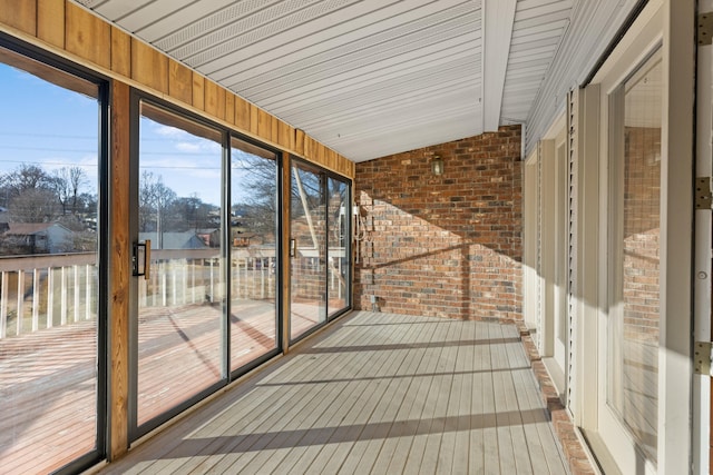 unfurnished sunroom featuring vaulted ceiling