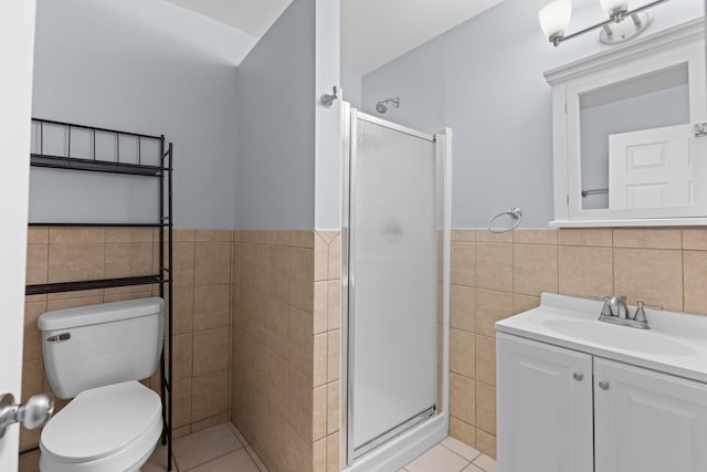 bathroom featuring tile walls, tile patterned flooring, a shower with shower door, and toilet