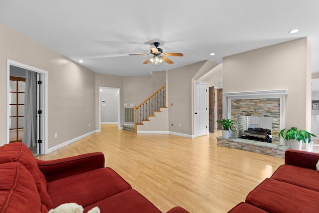 living room with a fireplace, light hardwood / wood-style floors, and ceiling fan