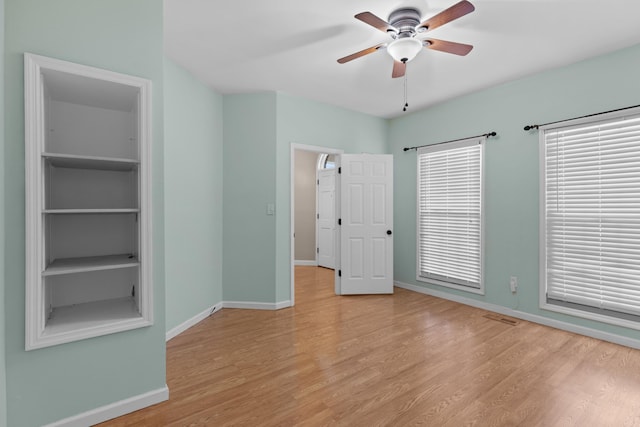 unfurnished bedroom featuring multiple windows, light hardwood / wood-style floors, and ceiling fan