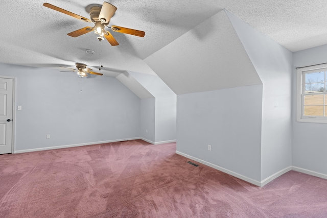 bonus room with light carpet, ceiling fan, vaulted ceiling, and a textured ceiling