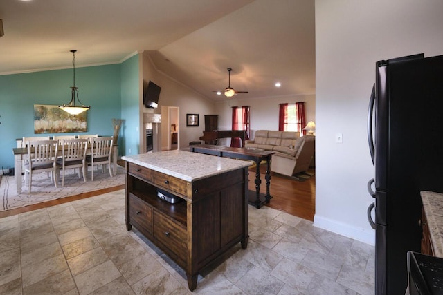 kitchen featuring pendant lighting, black fridge, ceiling fan, a kitchen island, and dark brown cabinetry