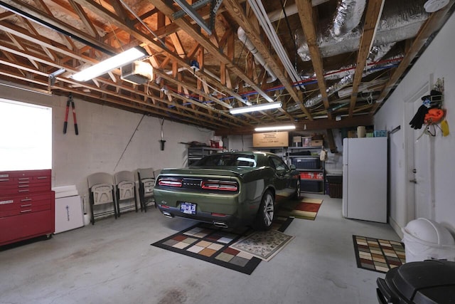 garage featuring white fridge and a garage door opener