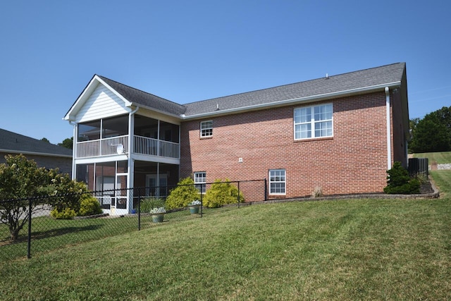 rear view of house with a yard, central air condition unit, and a sunroom