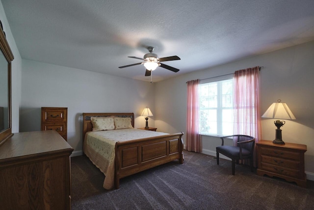 bedroom featuring a textured ceiling, dark carpet, and ceiling fan