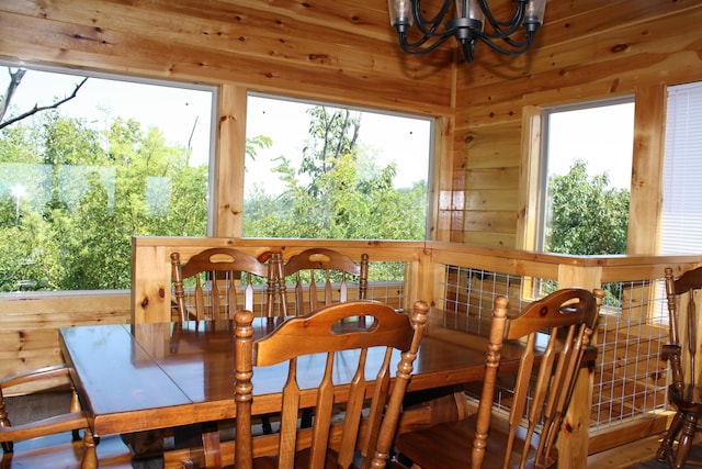 dining room featuring wood walls and an inviting chandelier