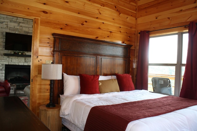 bedroom with a stone fireplace and wooden walls