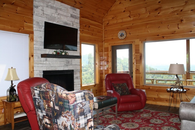 living room with wooden walls, a fireplace, hardwood / wood-style floors, and lofted ceiling