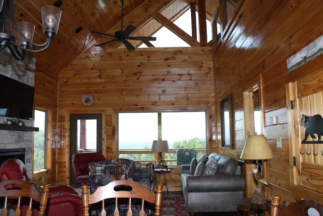 living room with wooden walls, a fireplace, high vaulted ceiling, and wood ceiling