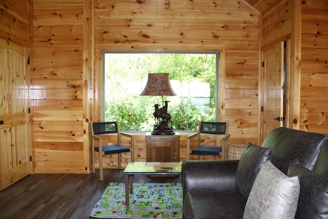 living area with lofted ceiling, dark hardwood / wood-style flooring, and wooden walls