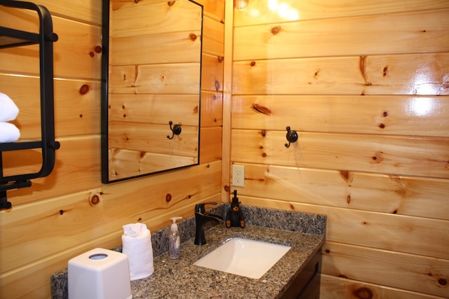 bathroom with vanity and wood walls