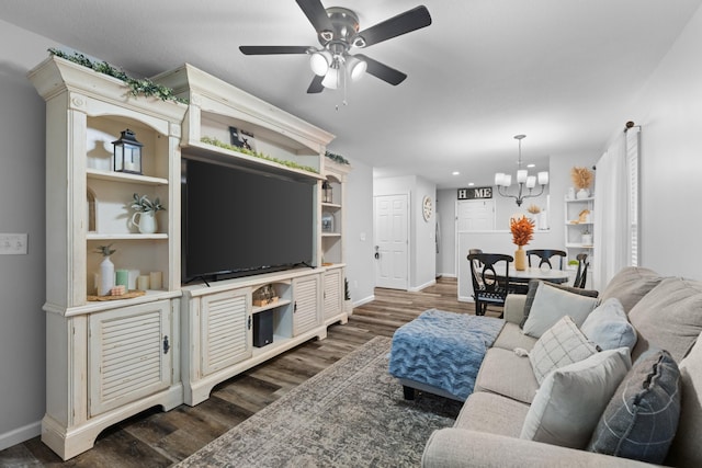 living room with ceiling fan with notable chandelier and dark hardwood / wood-style flooring