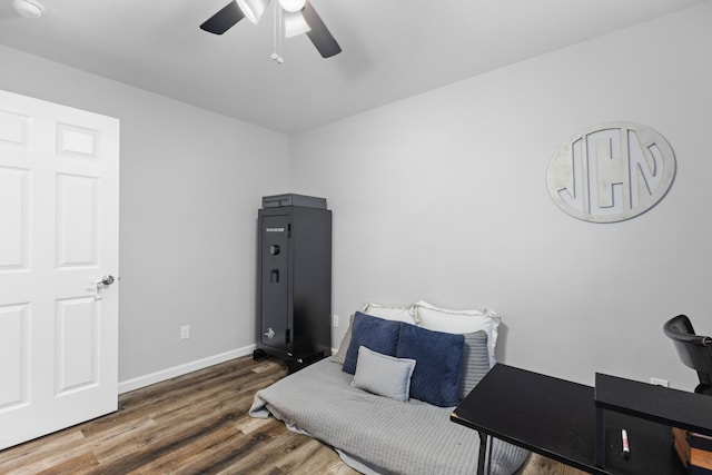 living area featuring ceiling fan and dark wood-type flooring