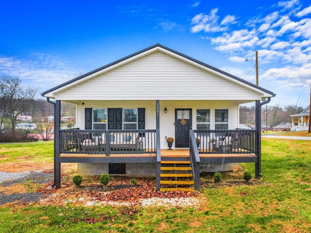 bungalow with covered porch and a front lawn