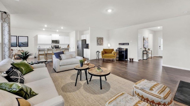 living room featuring wood finished floors, recessed lighting, and baseboards