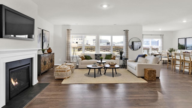 living room featuring dark wood finished floors, recessed lighting, and a glass covered fireplace