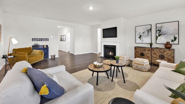 living area featuring wood finished floors, baseboards, a fireplace with flush hearth, and recessed lighting