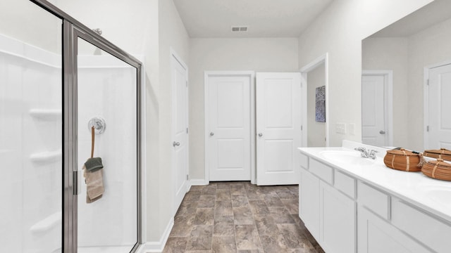 full bath featuring a shower stall and double vanity
