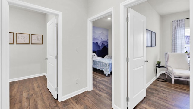 hallway featuring dark wood finished floors and baseboards