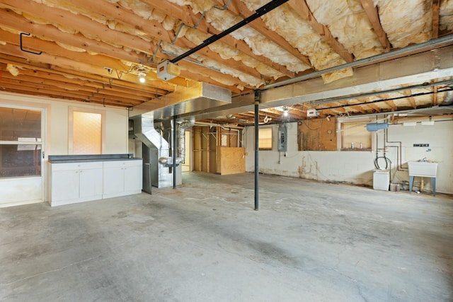 basement featuring electric panel and sink