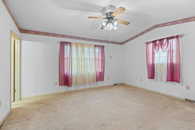 carpeted spare room featuring ceiling fan and vaulted ceiling