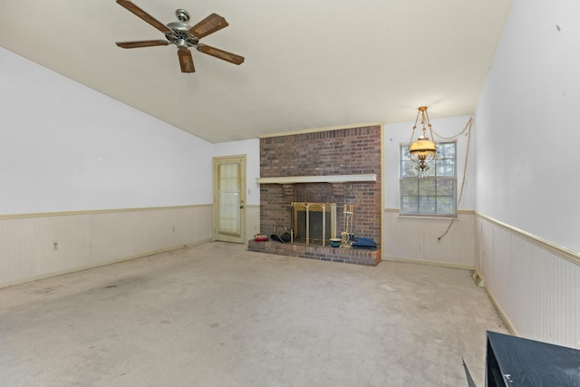 unfurnished living room with ceiling fan, light colored carpet, a fireplace, and vaulted ceiling