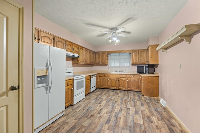 kitchen with a textured ceiling, white appliances, ceiling fan, sink, and light hardwood / wood-style flooring