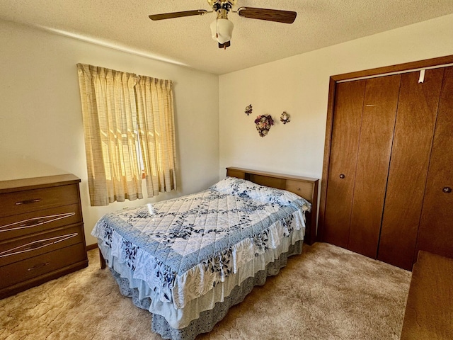 carpeted bedroom featuring ceiling fan, a closet, and a textured ceiling