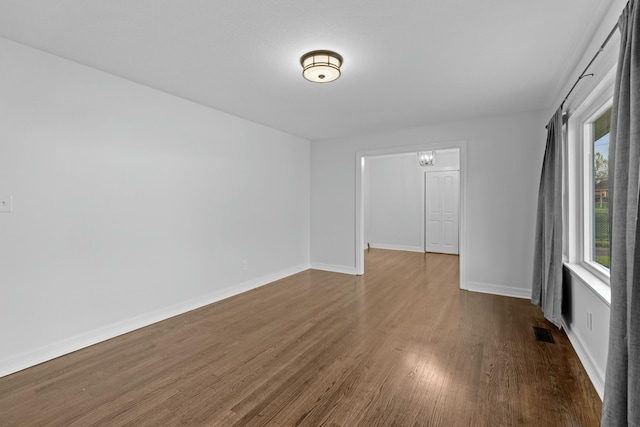 spare room featuring dark wood-style flooring, baseboards, and visible vents