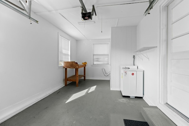 garage with separate washer and dryer, baseboards, and a garage door opener