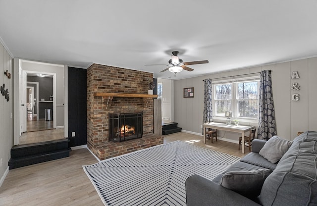 45 Link Hills Cir, Greeneville, TN 37743 - living room with light wood-type flooring, a ceiling fan, a fireplace, a decorative wall, and baseboards