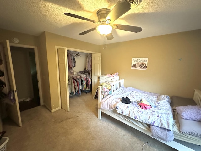 bedroom featuring carpet flooring, ceiling fan, a closet, and a textured ceiling